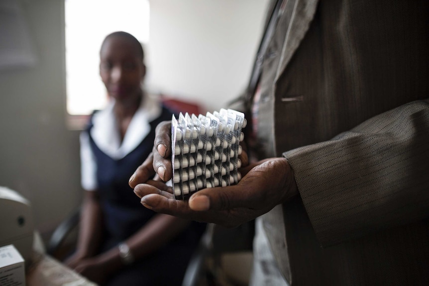 A doctor holds a month's worth of medication for an HIV positive patient.