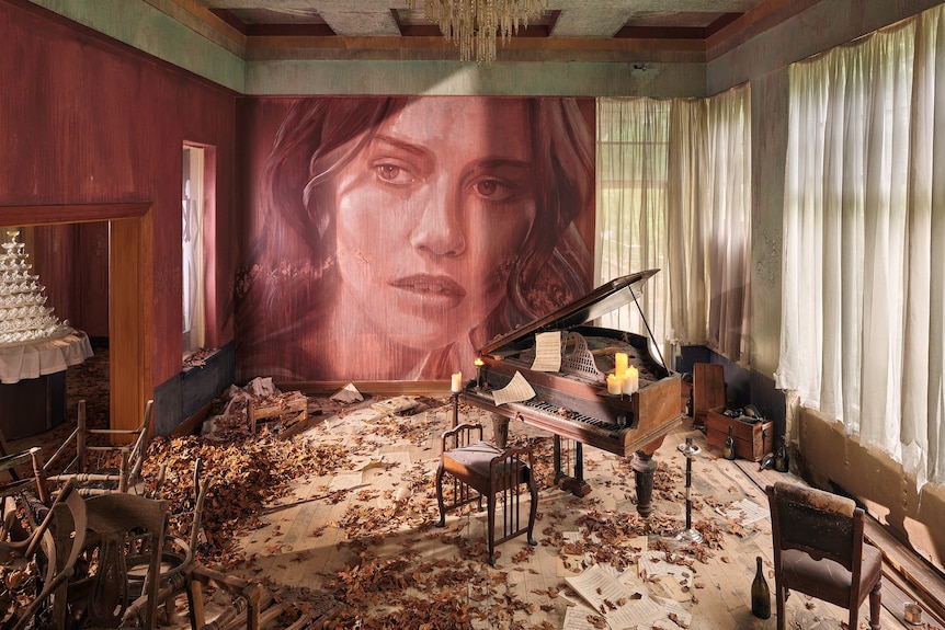 Piano room in decaying mansion with portrait of woman on wall