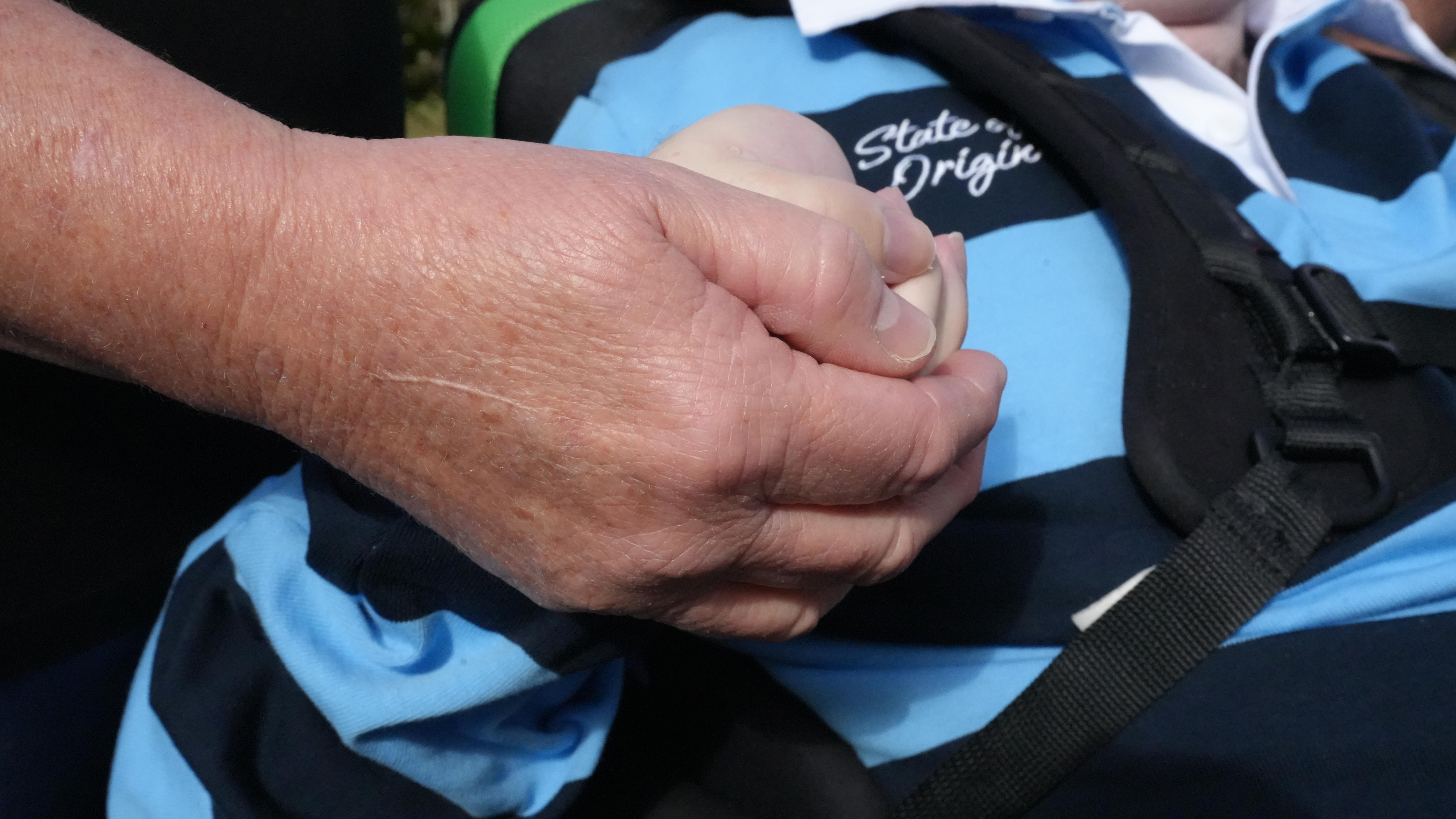 A woman holding a man's hand.