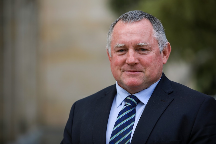 A man in a suit and tie standing outside WA's parliament house. 