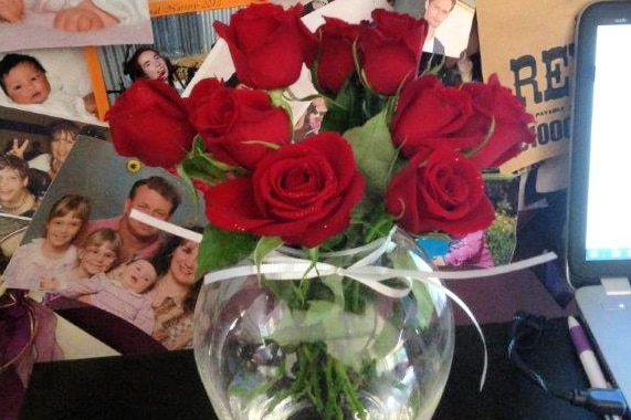 red roses on a writer's desk