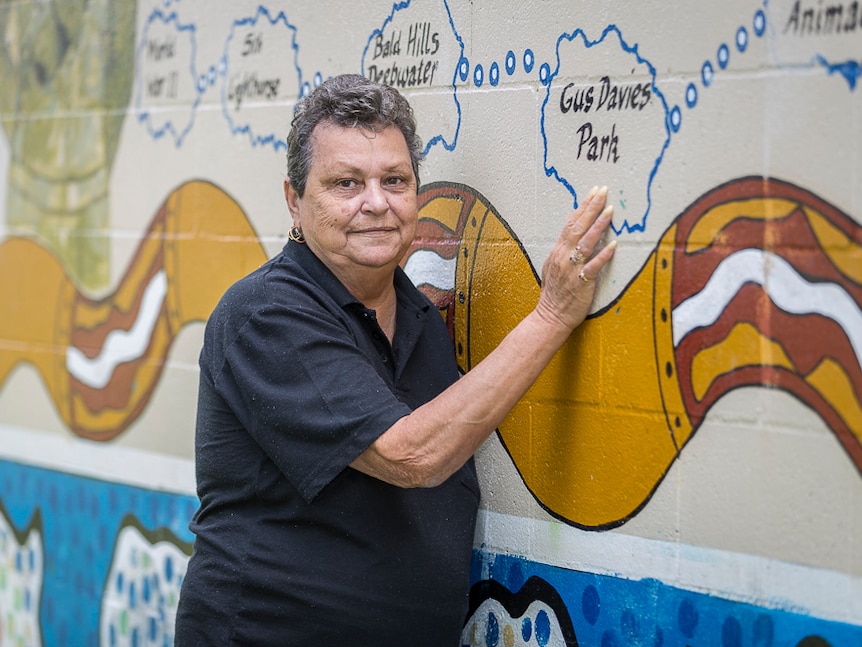 Aunty Paula Williamson-Babarovich stands by the mural at Gus Davies Park.