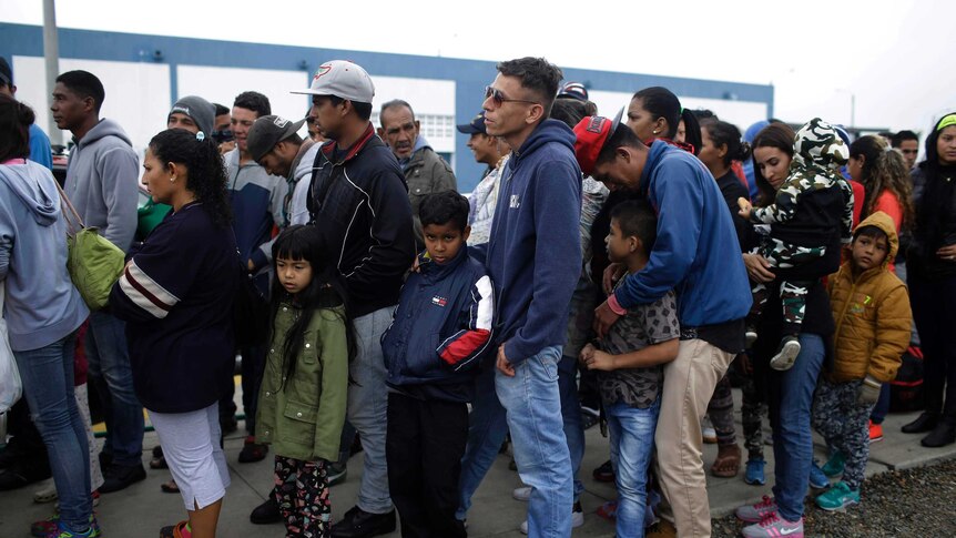 Venezuelan migrants wait in line before deadline on new regulations that demand passports from migrants in Peru.