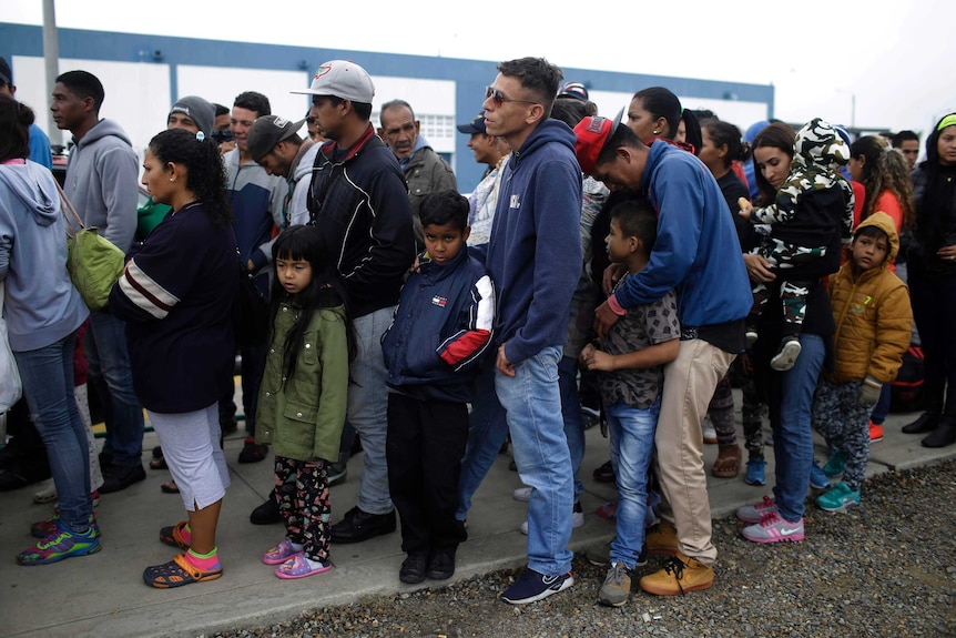 Venezuelan migrants wait in line before deadline on new regulations that demand passports from migrants in Peru.