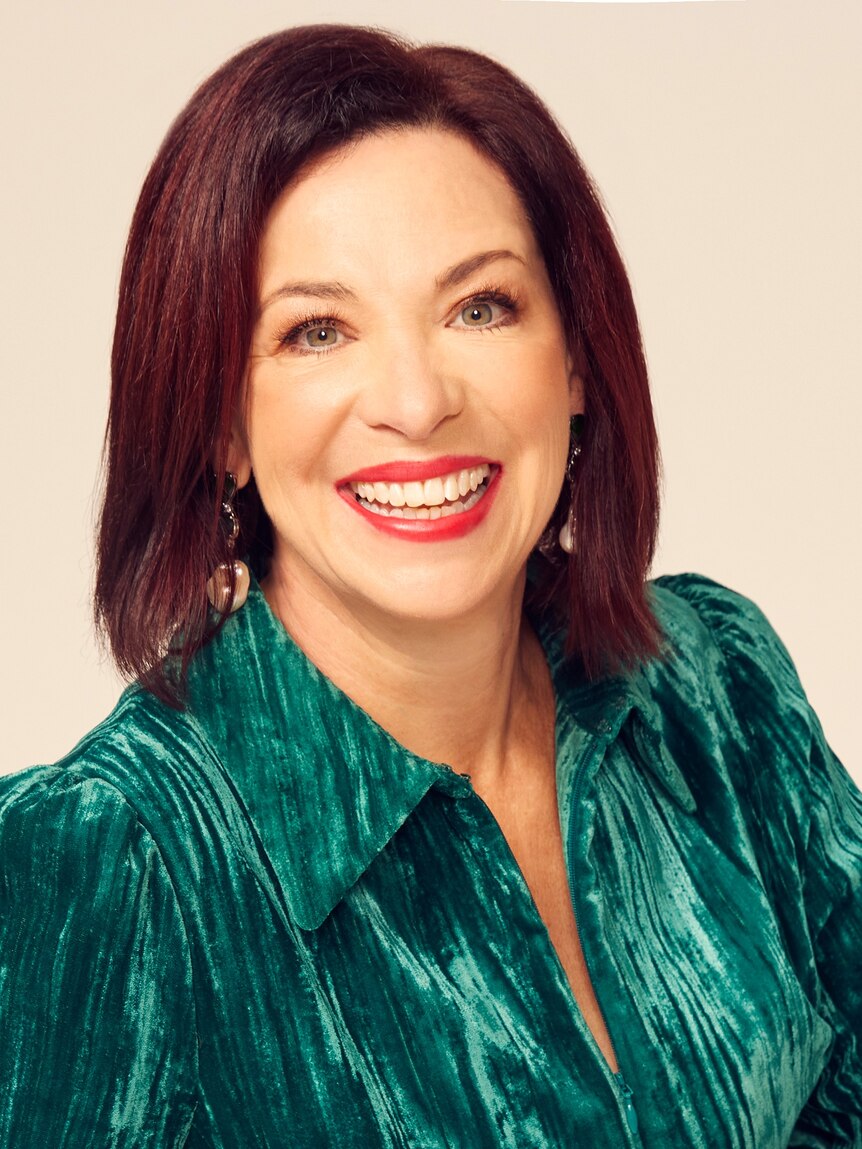 Catherine Fitzpatrick wearing a green blouse and red lipstick with dark red hair