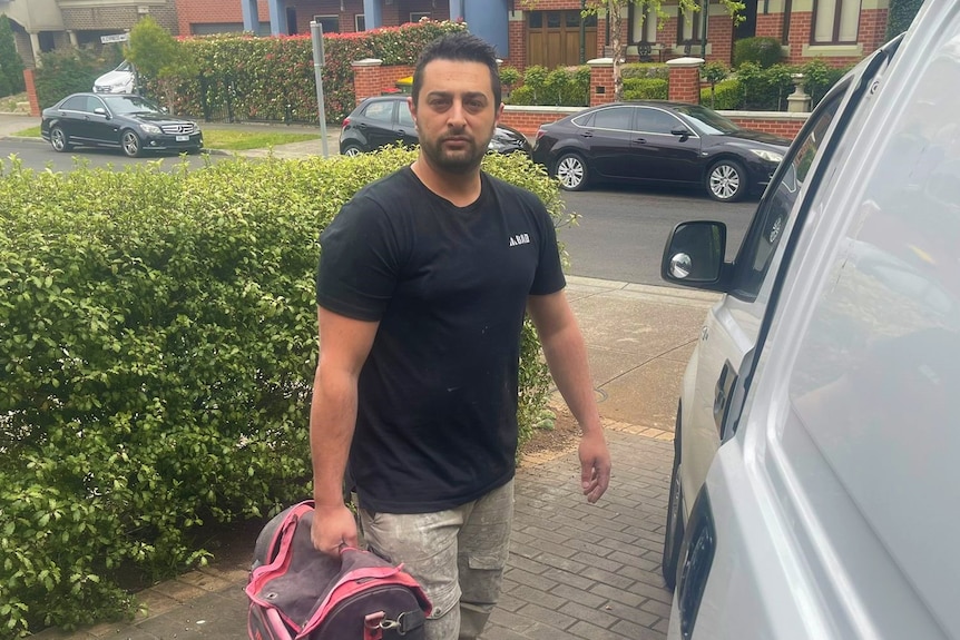 A tradesman holding a bag