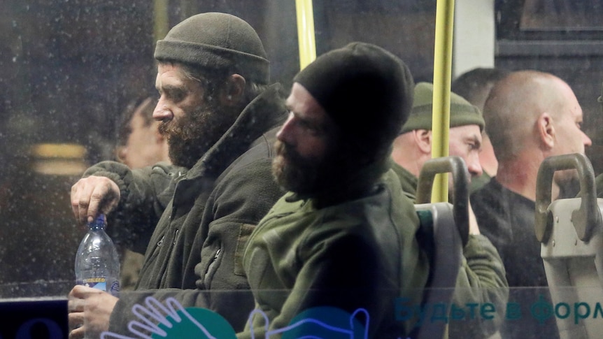 Ukranian soldiers inside a bus escorted by Russian military leaving the Azovstal steelworks in Mariupol.