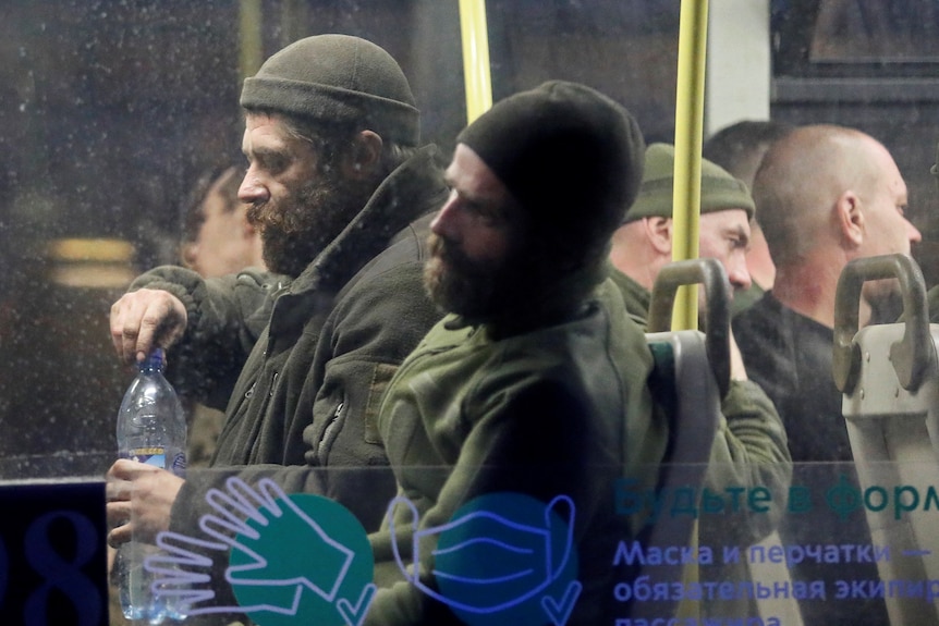 Ukranian soldiers inside a bus escorted by Russian military leaving the Azovstal steelworks in Mariupol.