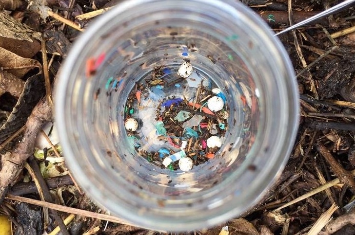 A glass filled with tiny flecks of coloured plastic