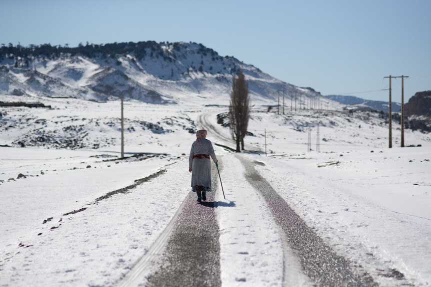 A woman walks home amidst heavy snowfall.