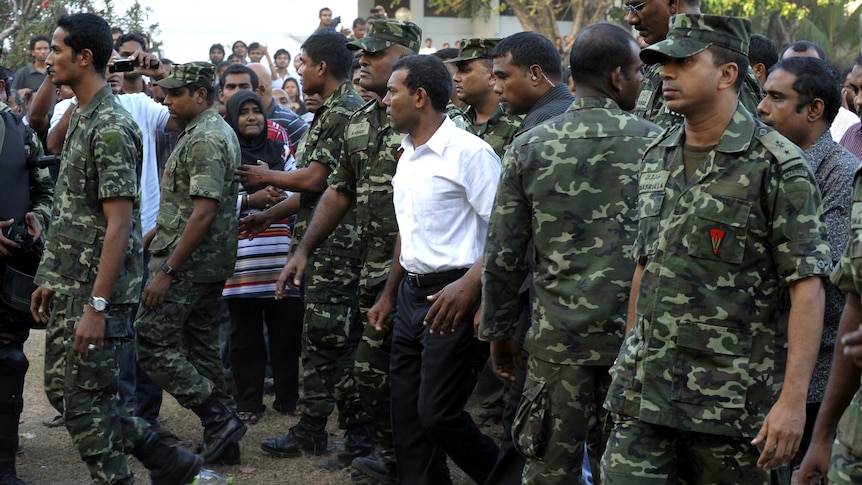 Former Maldivian president Mohamed Nasheed (wearing white) says he was forced from power at gunpoint.