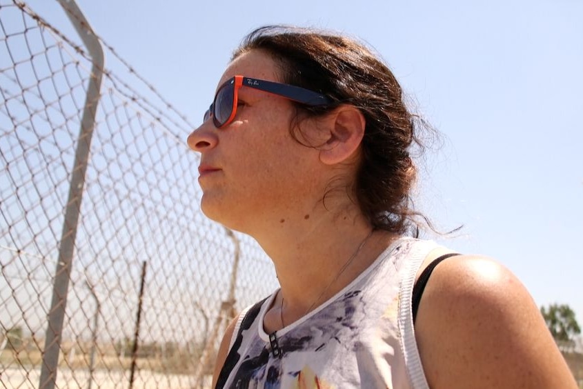 Israeli mother Yael Lachyani looks toward a wire fence in Gaza.