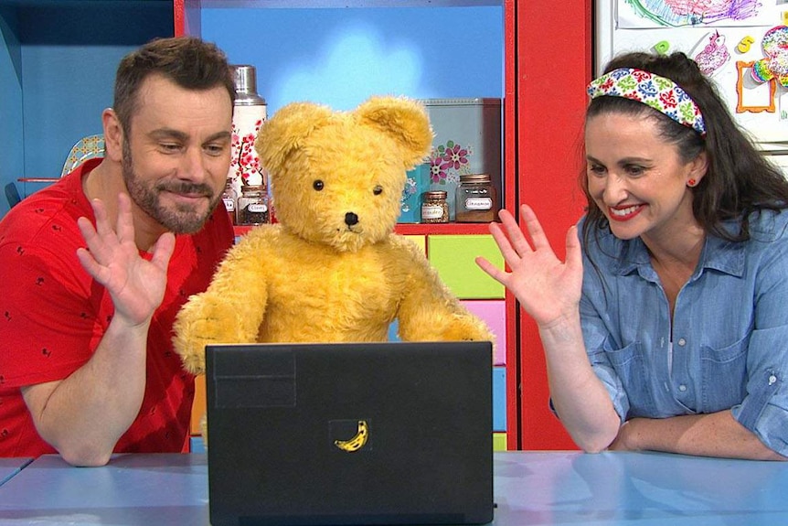 Teo and Emma on the Play School set. They are waving to friends on the lap top top screen.