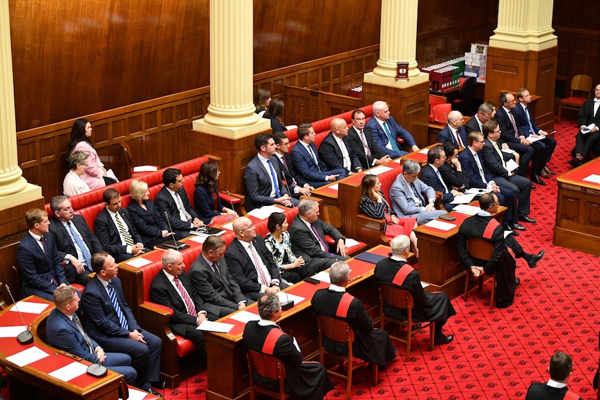 A group of mostly men in suits sit in the House of Assembly in SA's Parliament.