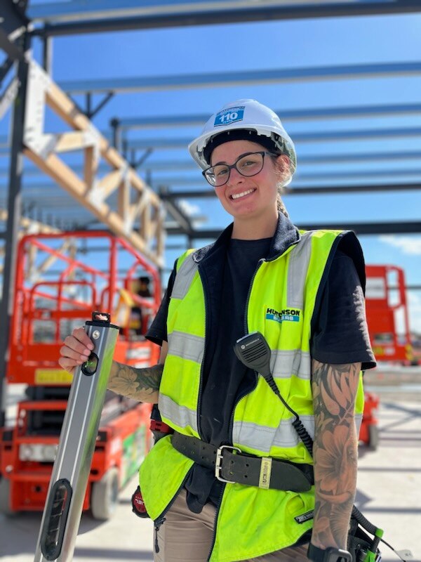 A tradie holds her tools