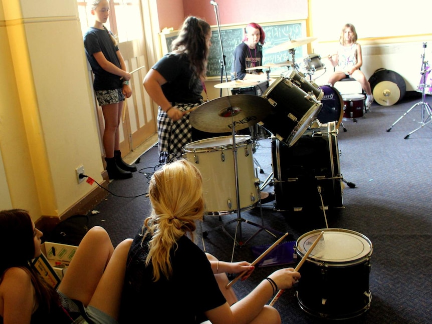 Girls taking part in a drum workshop at the Girls Rock! music camp in Canberra.