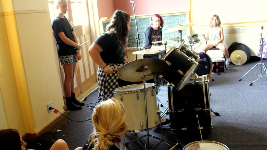 Girls taking part in a drum workshop at the Girls Rock! music camp in Canberra.