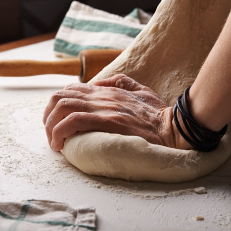 Hands kneading bread dough.