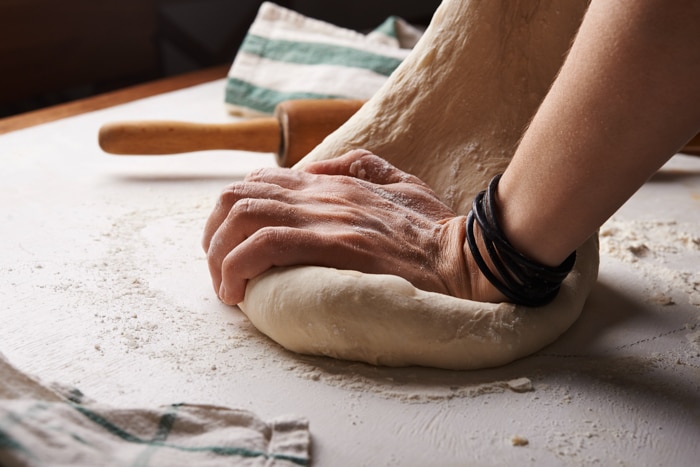 Hands kneading bread dough.