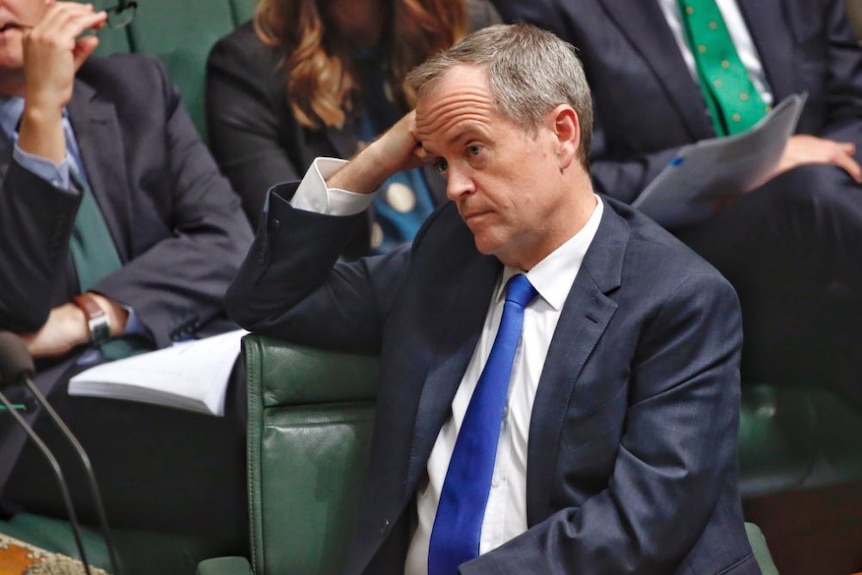 Opposition Leader Bill Shorten leans on his right arm, looking bored, tired or unimpressed during Question time.