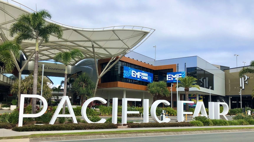 A sign reading PACIFIC FAIR outside a shopping centre, by the street