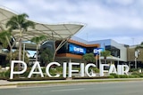 A sign reading PACIFIC FAIR outside a shopping centre, by the street