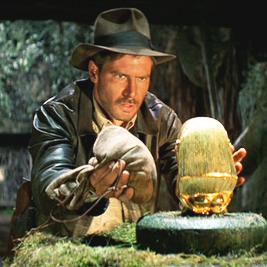 Indiana Jones prepares to swap a gold idol for a bag of sand in a scene from Raiders Of The Lost Ark.