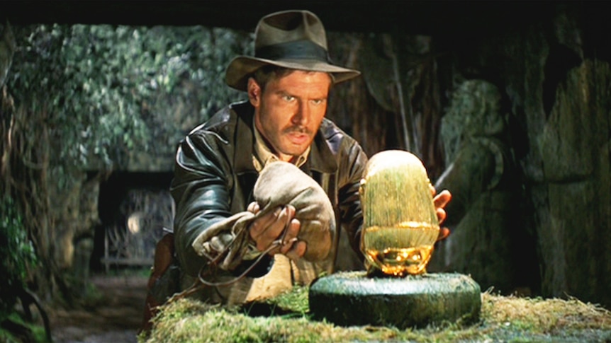 Indiana Jones prepares to swap a gold idol for a bag of sand in a scene from Raiders Of The Lost Ark.
