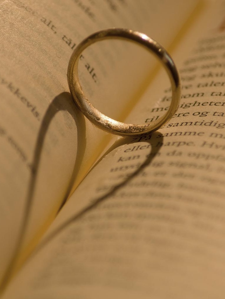 Gold wedding ring resting on book