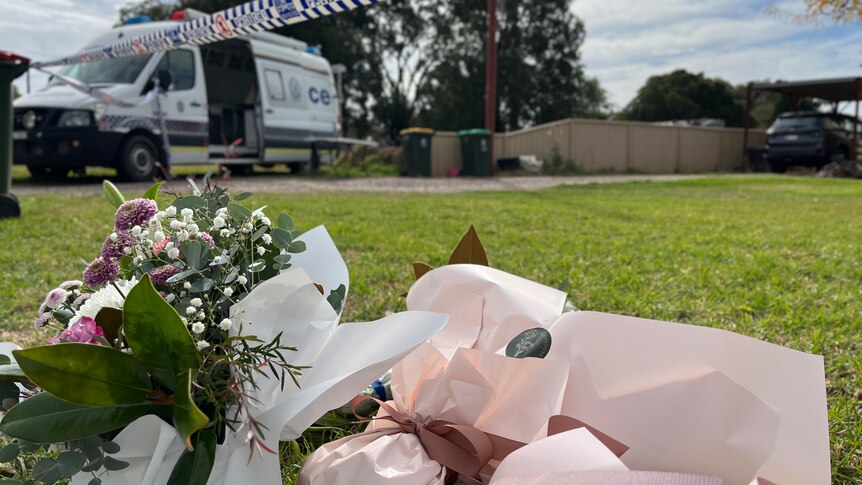 Flowers, in the foreground, left near police tape, in the background, in Forbes as part of Molly Ticehurst investigation
