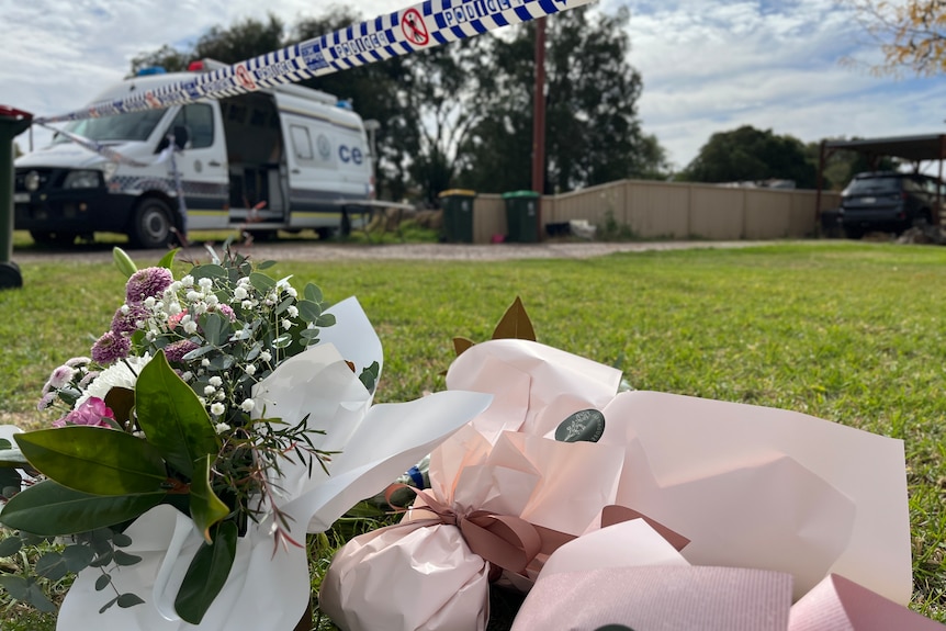 Flowers, in the foreground, left near police tape, in the background, in Forbes as part of Molly Ticehurst investigation