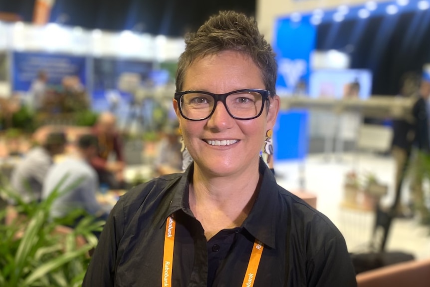 Women wearing glasses with short black hair smiles at camera