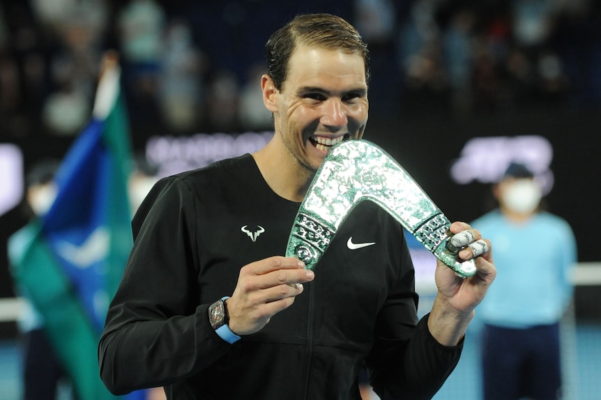 Tennis player holds trophy