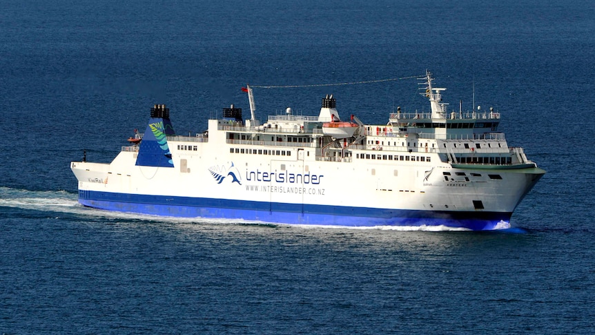 A large blue and white ferry travels across the water.