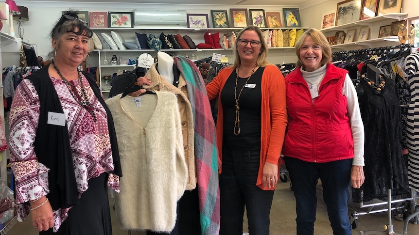 Three women standing inside a clothing shop