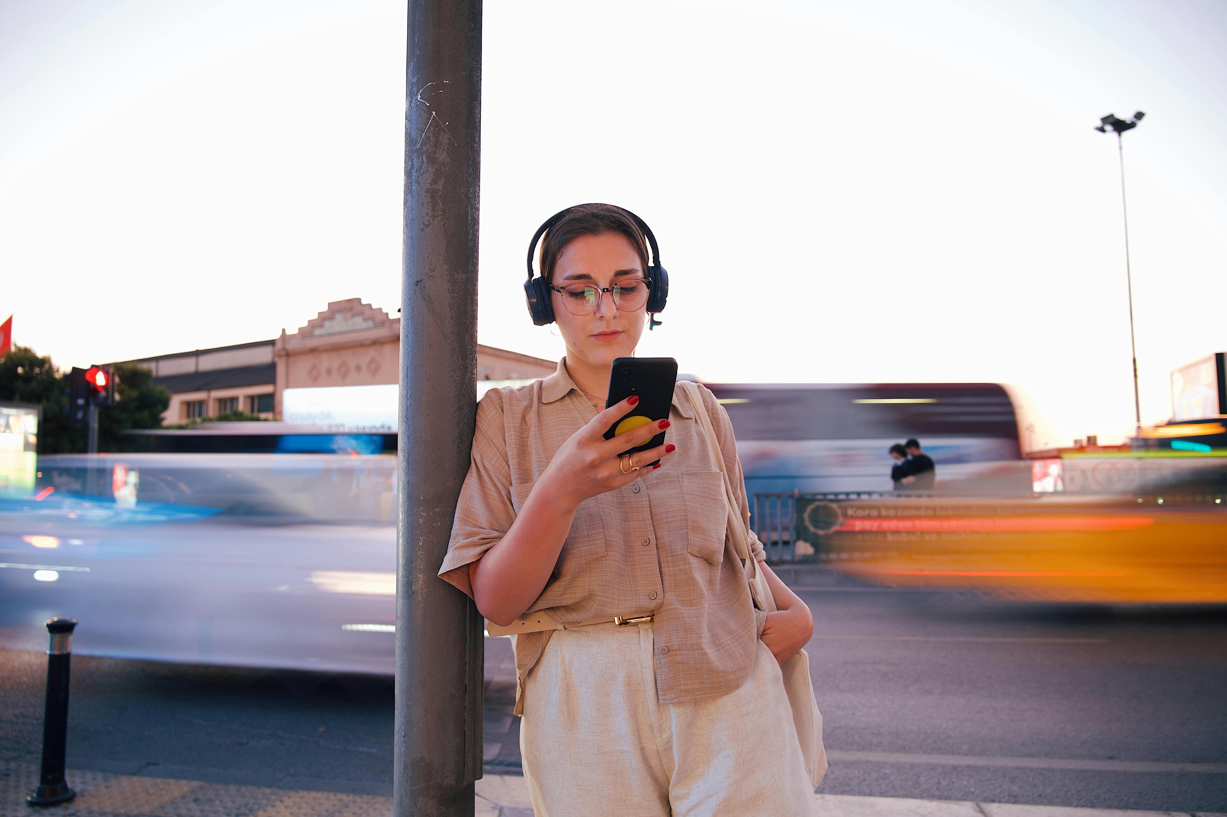 Hipster woman listens to earphones on busy street
