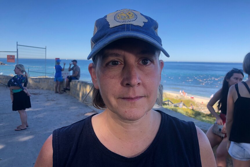 Michelle Striepe wearing a blue cap while standing on a footpath close to the ocean.