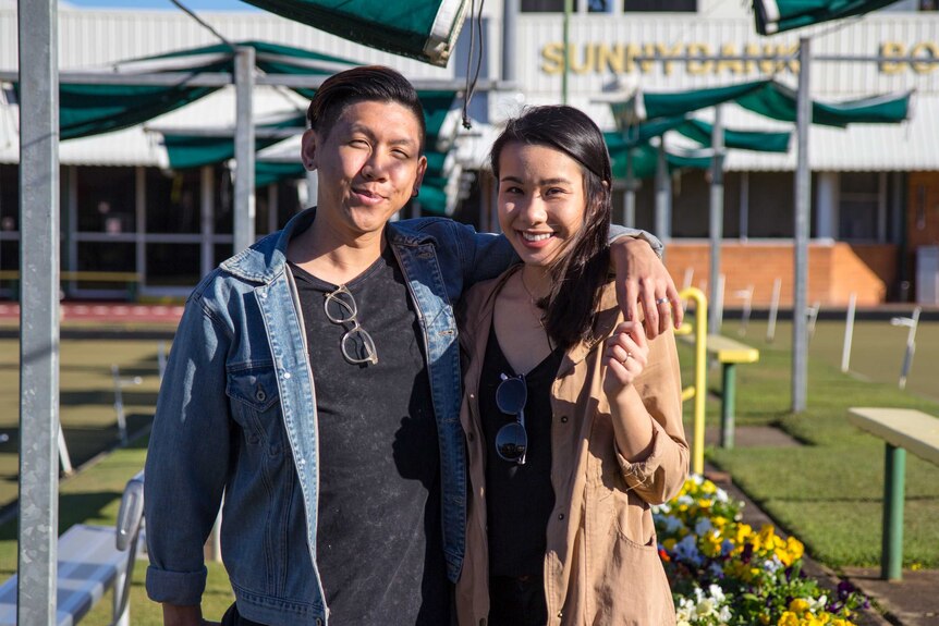 Mikey and Heidi Tai stand in front of the Sunnybank Lawn Bowls Club.