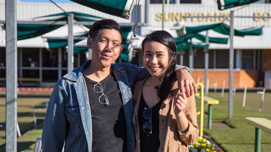 Mikey and Heidi Tai stand in front of the Sunnybank Lawn Bowls Club.