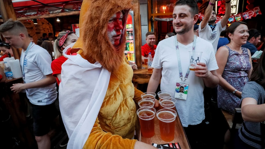 Supporters of England drink beer after their World Cup match.