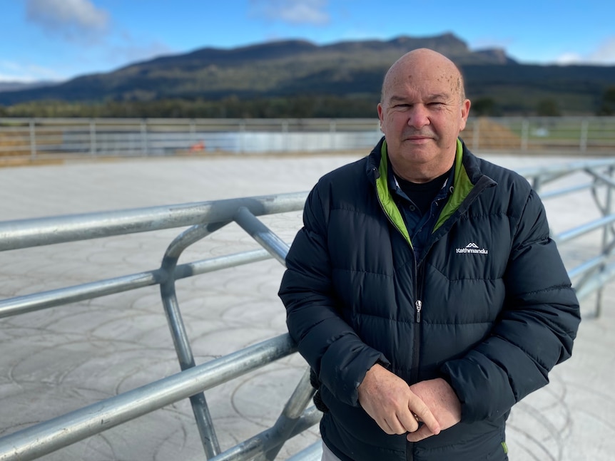 Financial consultant Greg Bott stands near a livestock pen.