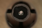 A close up of a diamond mounted on an industrial drill bit.