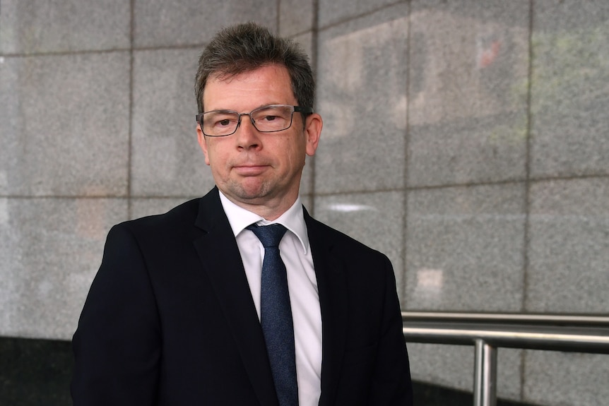 A man wearing a suit and glasses