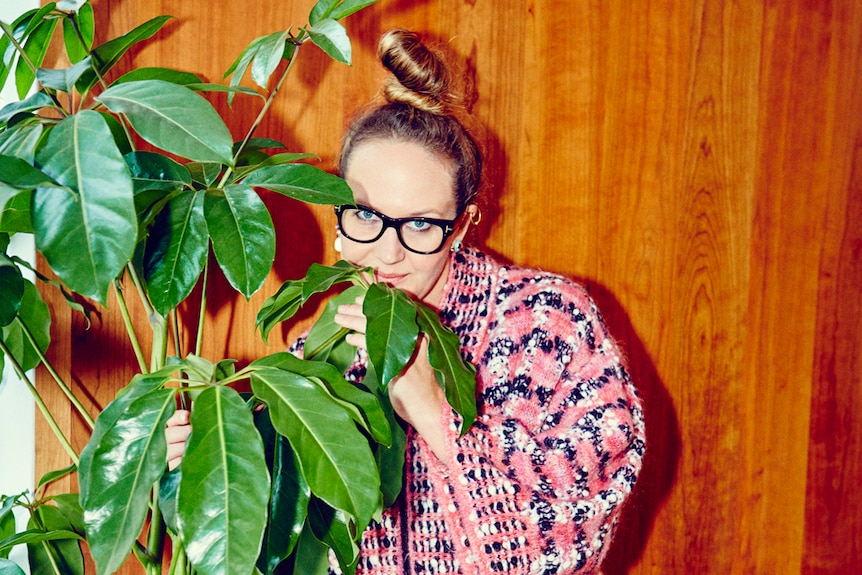 Del Kathryn Barton hiding behind a large indoor plant