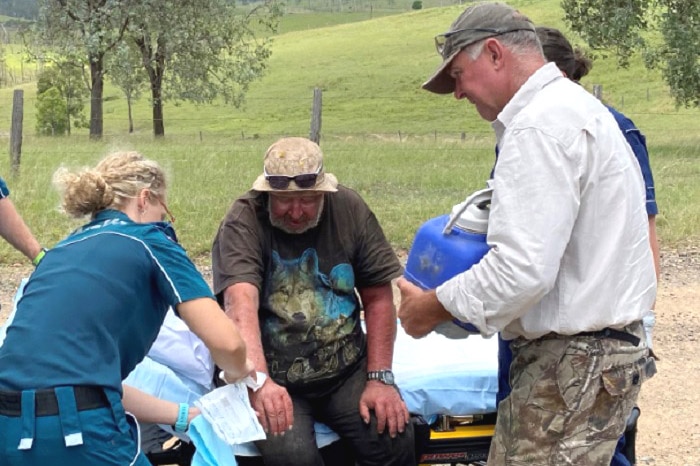 A man on a gurney being treated by paramedics