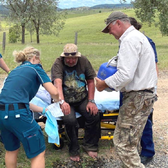 A man on a gurney being treated by paramedics