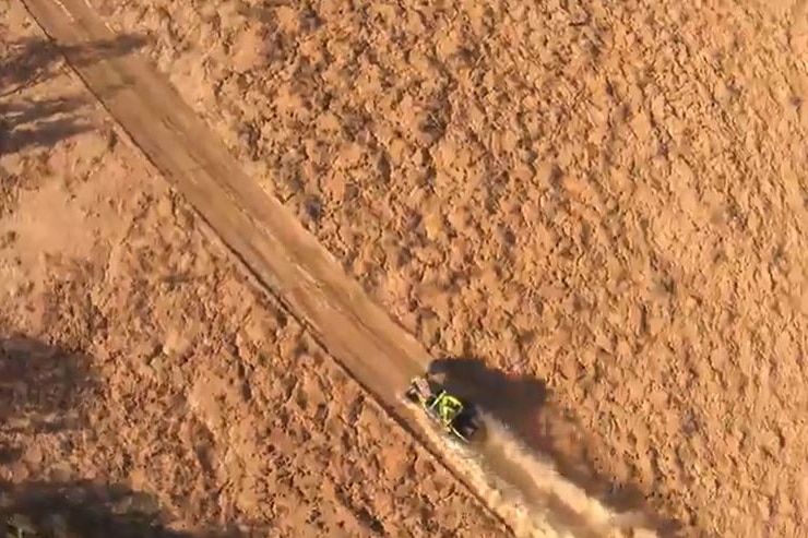 An aerial shot of a car tearing through the desert.