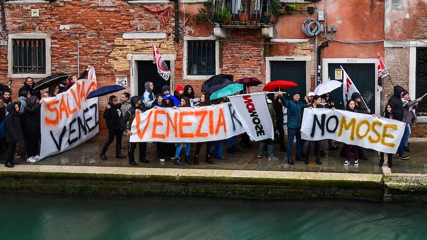 Protesters with signs in the streets of Venice.