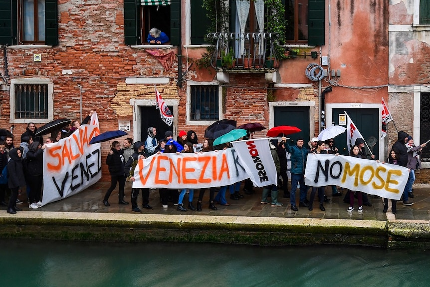 Protesters with signs in the streets of Venice.