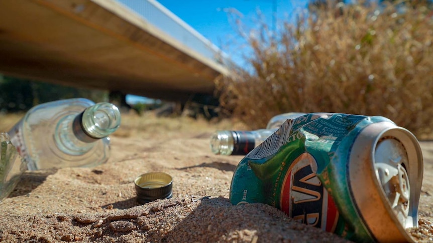 Empty liquor bottles and cans lay in the dry Todd River. 